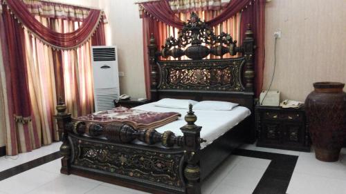 卡拉尔哥特Holiday Inn Guest House的一间卧室配有一张华丽的木架床