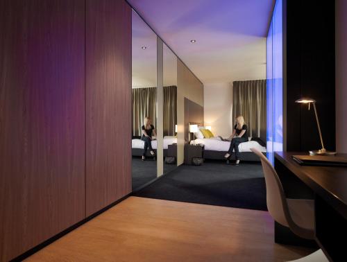 凯尔克拉Fletcher Hotel-Restaurant Parkstad- Zuid Limburg的两名妇女坐在酒店房间的床上