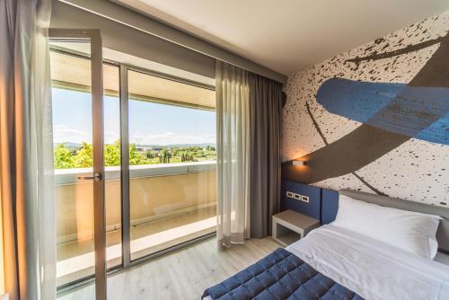 卡莱扎诺JR Hotels Gigli Firenze的一间卧室设有一张床和一个大窗户