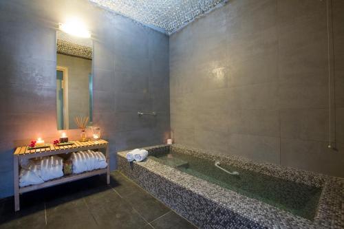 卢特拉艾季普苏伊利安Spa酒店的带浴缸和镜子的浴室