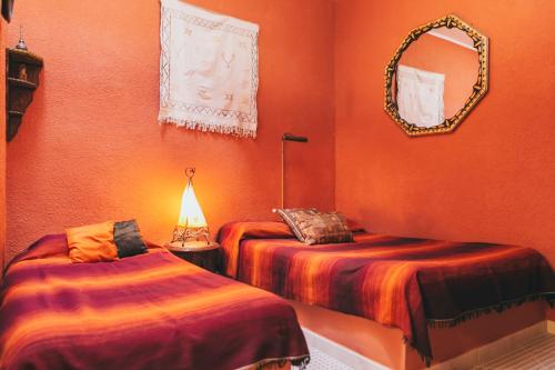 马拉加El Riad Andaluz的一间设有两张床的客房和墙上的镜子