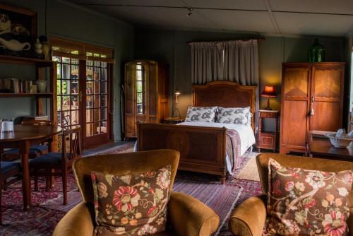 克尼斯纳Woodcutters Forest Cottages的卧室配有一张床和一张桌子及椅子