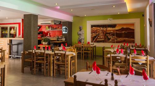 比斯卡罗斯意大利酒店的餐厅配有桌椅和红色餐巾