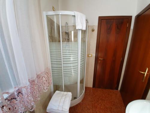 威尼斯Casa Alla Fenice的浴室里设有玻璃门淋浴