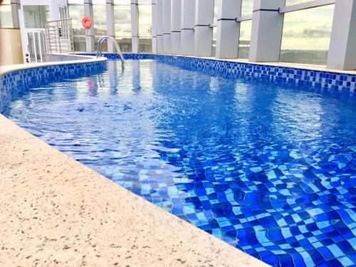 巴西利亚Flat Fusion Setor Hoteleiro Norte com serviço diário de limpeza的一座蓝色瓷砖的游泳池