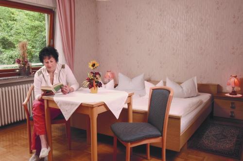 Bad Endbach伯克旅馆的坐在桌子旁读书的女人