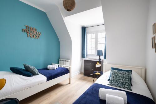 圣马洛L'Anémone的一间卧室设有两张床和蓝色的墙壁