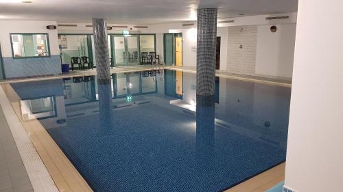 马拉莫尔Pier Head Hotel Spa & Leisure的一座铺有蓝色瓷砖地板的大型游泳池
