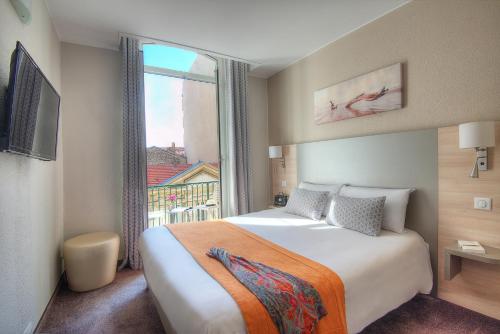 尼斯杜米迪i酒店的酒店客房设有一张床和一个大窗户