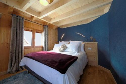 莱鲁斯Gîte du Bief de la Chaille的一间卧室设有一张床和蓝色的墙壁