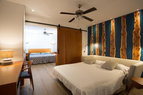 米乔尔海滩卡马里酒店的一间卧室配有一张床和一张带吊扇的书桌