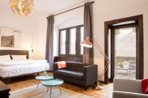 科赫姆Hotel Villa Vie Cochem的一间卧室配有一张床、一张沙发和一把椅子