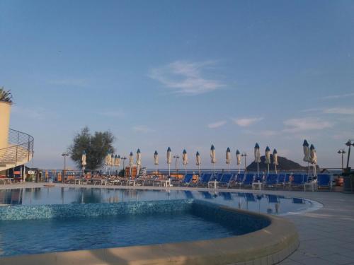 阿尔本加Appartamento Quadrilocale的一个带椅子和遮阳伞的游泳池