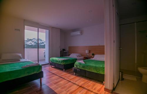 内瓦Hotel Berdez的酒店客房,配有两张带绿床单的床