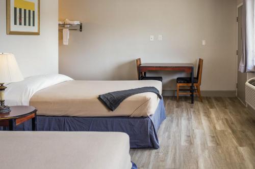 博蒙特Merit Inn and Suites的酒店客房配有两张床和一张书桌