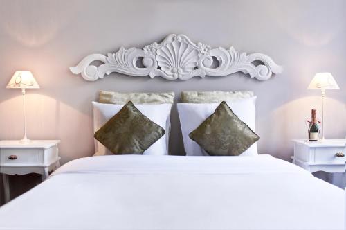 布鲁塞尔布鲁塞尔X2食宿酒店的卧室配有一张白色床、两张桌子和两盏灯。