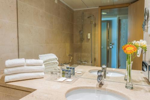 波尔图HF伊帕内玛波尔图的浴室水槽,配有花瓶和毛巾