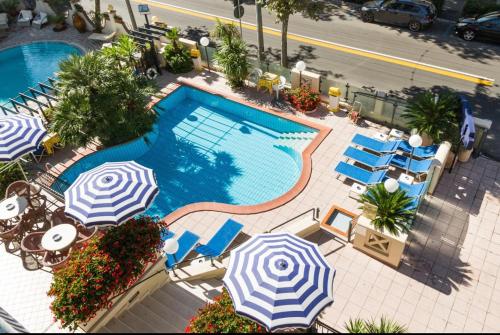 里米尼克巴尔托酒店的享有带遮阳伞和椅子的游泳池的顶部景致