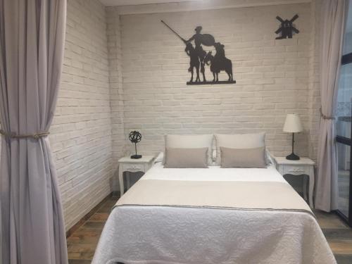 托莱多Ático del Rojas的一间卧室设有一张床和一面墙