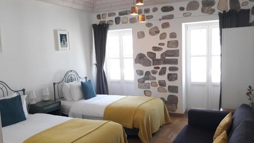 塔维拉Calcada Guesthouse的酒店客房设有两张床和窗户。