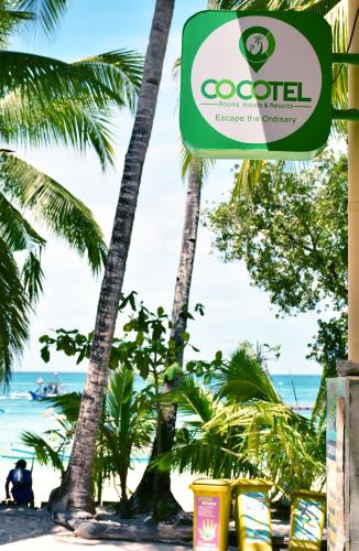 长滩岛Boracay Morning Beach Resort by Cocotel - Fully Vaccinated Staff的棕榈树和海洋海滩上的标志