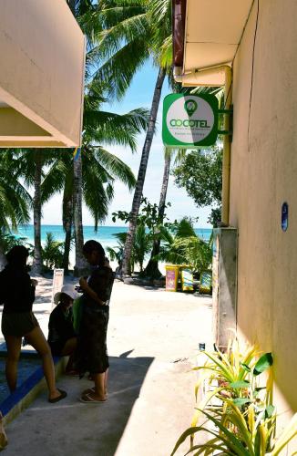 长滩岛Boracay Morning Beach Resort by Cocotel - Fully Vaccinated Staff的一群人站在海滩附近的一座建筑外