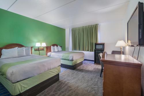 迪金森Badlands Inn & Suites的酒店客房配有两张床和一张书桌