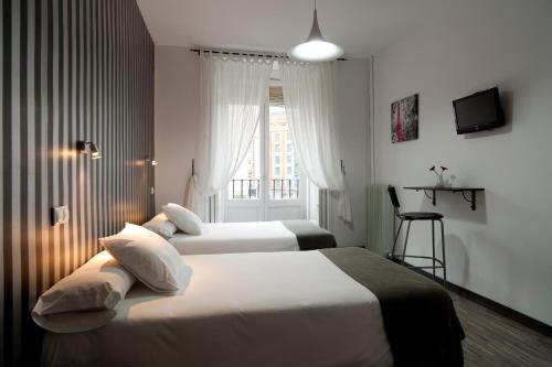 马德里马德里节日旅馆的配有窗户的酒店客房内的两张床