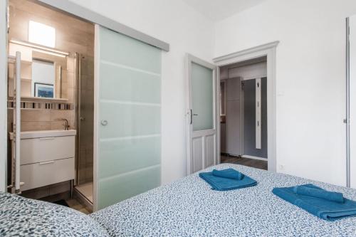 布达佩斯Kincsem Budapest Apartman的一间卧室配有一张带2条蓝色毛巾的床