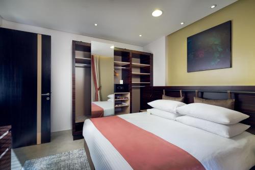 达曼TIME Dammam Residence的卧室配有带白色枕头的大床