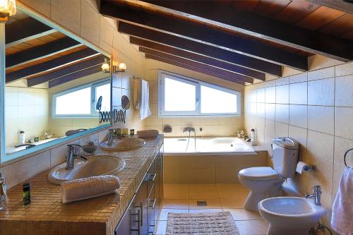 巴尔巴蒂Villa Dimeli的一间带两个盥洗盆、浴缸和卫生间的浴室