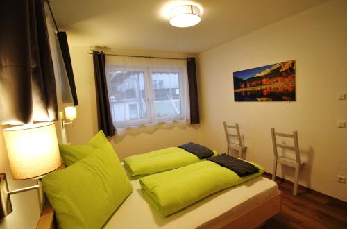 拉姆绍达赫斯坦Haus Intaba的一间卧室设有一张绿色的床和一个窗户。