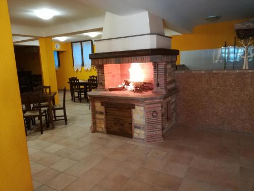 SantʼUrbanoAgriturismo Isola Verde的一间设有用餐室的客房内的砖砌壁炉