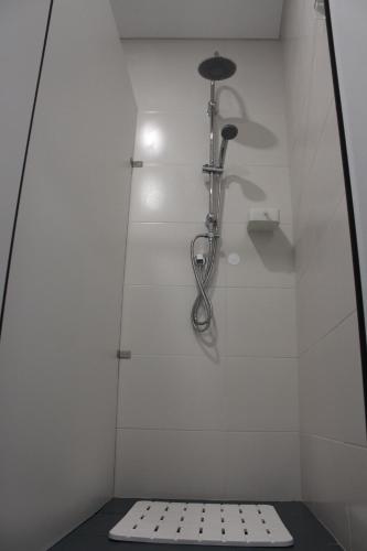 菲盖拉-达福什UAU Hostel的带淋浴的浴室(带白色墙壁)
