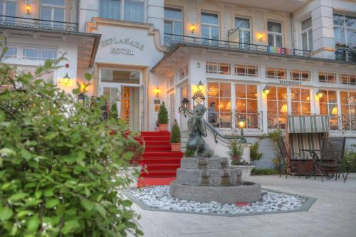 黑灵斯多夫SEETELHOTEL Villa Esplanade mit Aurora的建筑前有雕像的酒店