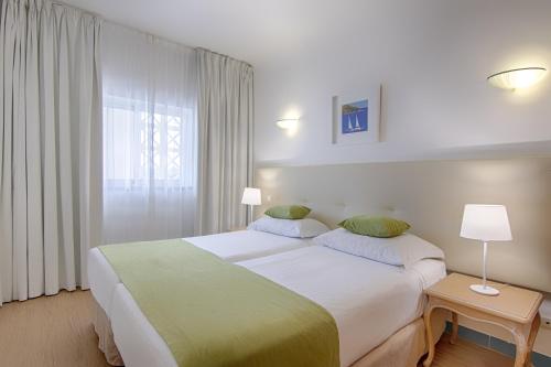 阿尔布费拉Luna Miramar Club的一间设有大床和窗户的酒店客房