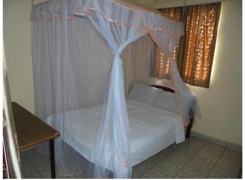 内罗毕Hotel Jaffers Nairobi的一间卧室配有一张带天蓬的床