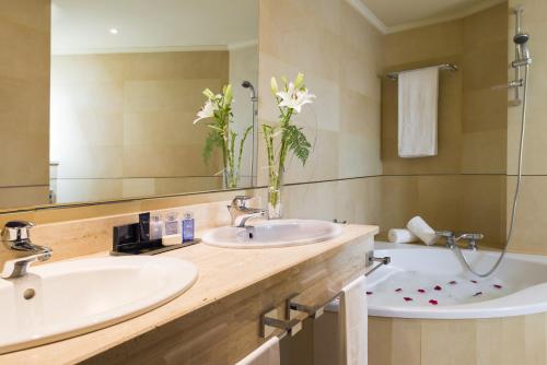 巴达霍斯巴达霍斯中心酒店的浴室设有2个水槽、浴缸和镜子