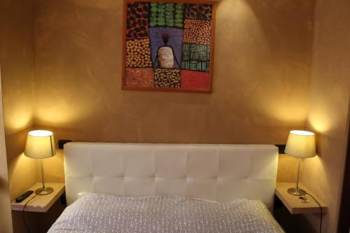 福贾老城区中心旅馆的卧室配有白色的床和两盏灯。