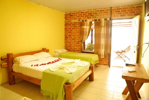 尼西亚弗洛雷斯塔Fazenda Bom Fim的黄色墙壁客房的两张床