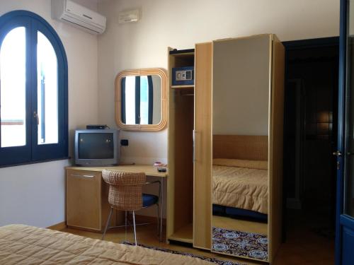 弗卡诺奥拉酒店的客房设有一张床、一张桌子和一台电脑