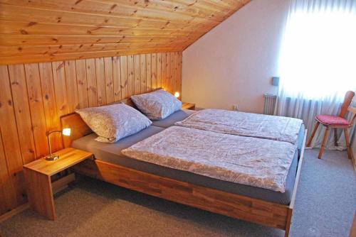 弗劳埃瑙Pension "Bayerwald"的一间卧室设有一张床和木制天花板