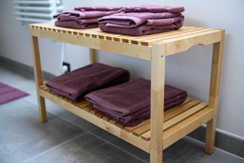 DworpB&B Hof ter Kouter的木制架子上装有紫色毛巾