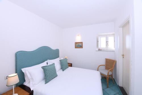 阿马尔菲Amalfitano Apartments的卧室内的一张白色床和蓝色床头板