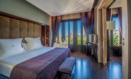 巴塞罗那凯撒弗斯特G.L纪念碑酒店的一间卧室设有一张床和一个美景窗户。