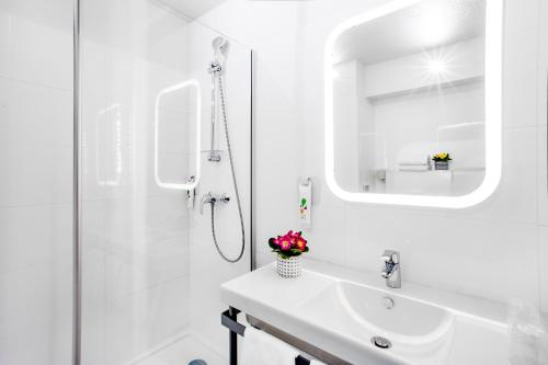 鲁西隆地区卡内ibis Styles Perpignan Canet En Roussillon的白色的浴室设有水槽和淋浴。