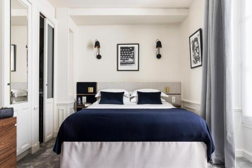 巴黎沃穆尔圣日耳曼酒店的一间卧室配有一张带蓝色床单的大床