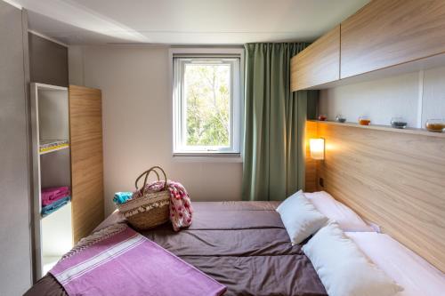 马恩河畔的尚格尼东方巴黎度假酒店的一间卧室设有一张床和一个窗口