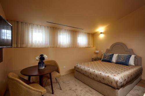 布拉加Signature Apartments Os Terceiros的一间卧室配有一张床、一张桌子和一台电视。