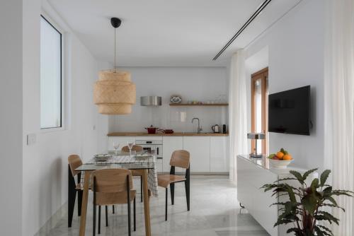 塞维利亚La casa del Lagar 10的厨房以及带桌椅的用餐室。